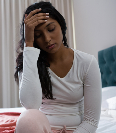 A young woman looks stressed and sad.